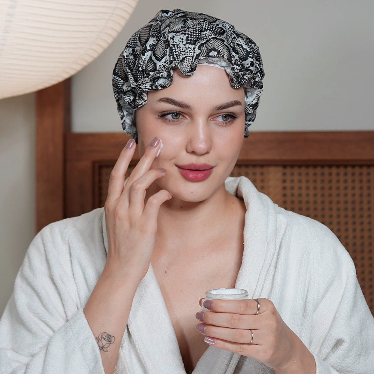 Snake print SMUG shower cap with elastic edge, designed to keep hair dry during showers.