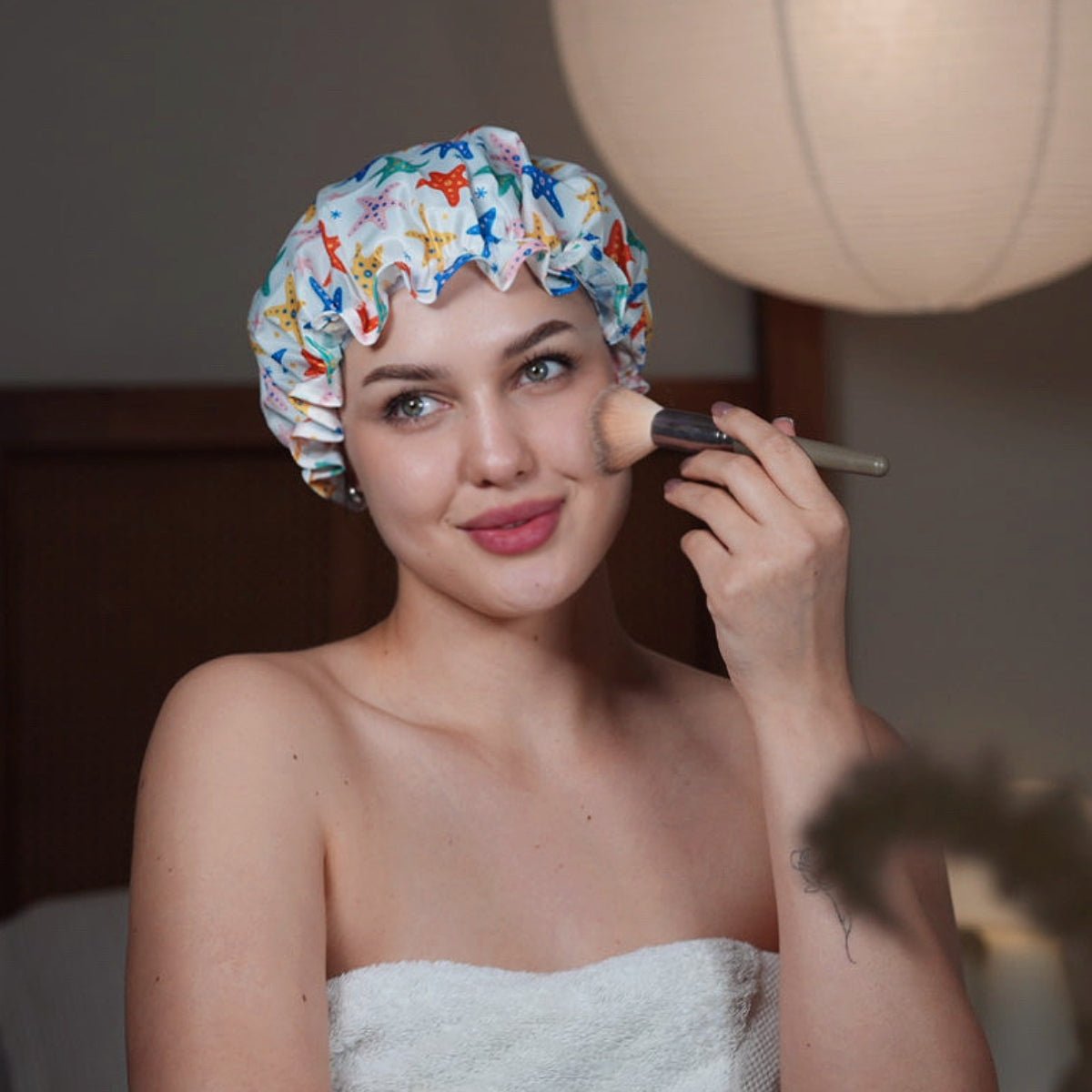 SMUG starfish print shower cap made of waterproof material, featuring a colorful starfish design for hair protection during showers.