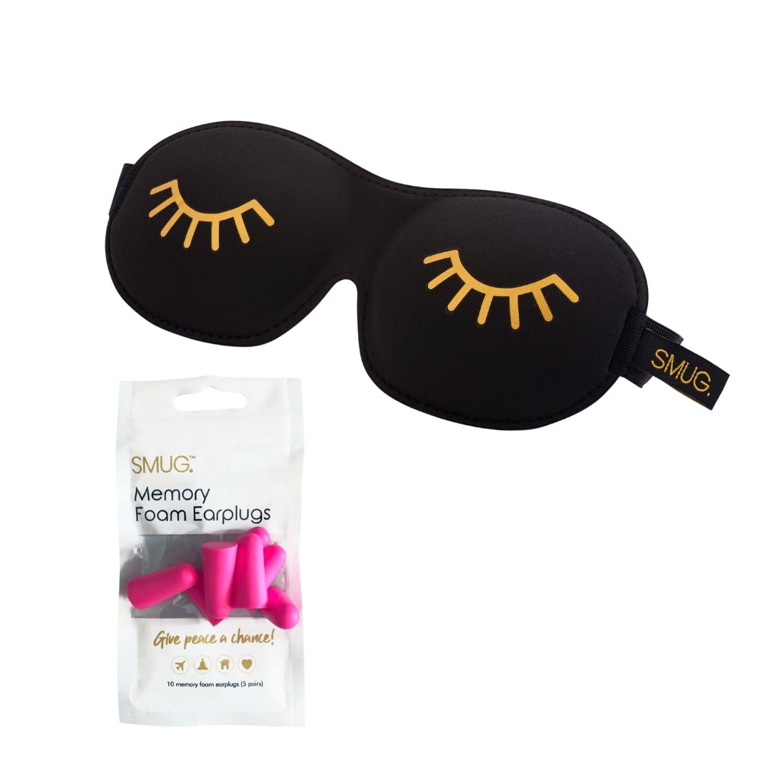 Contoured black sleep mask with wink print and earplugs from SMUG, designed for comfortable blackout sleep.