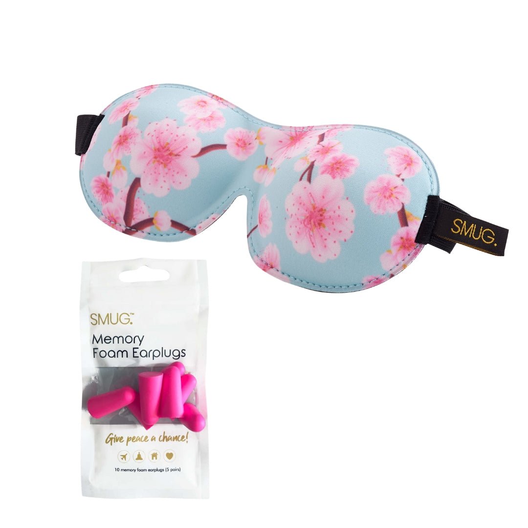 Contoured 3D black sleep mask with cherry blossom print by SMUG, designed to block light and fit comfortably over the eyes.