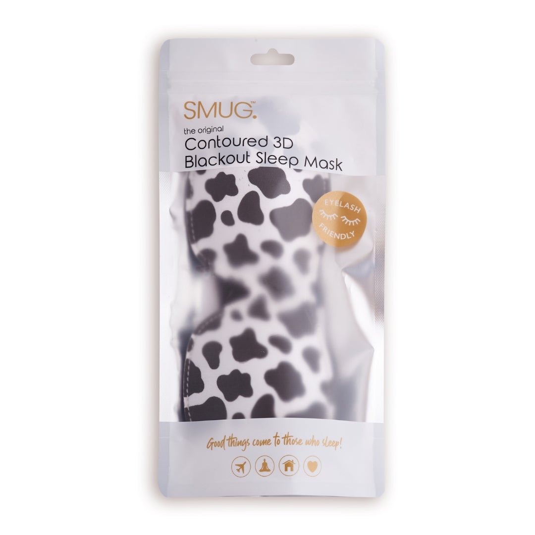 Contoured SMUG sleep mask with black cow print design, designed for blackout and comfortable sleep.