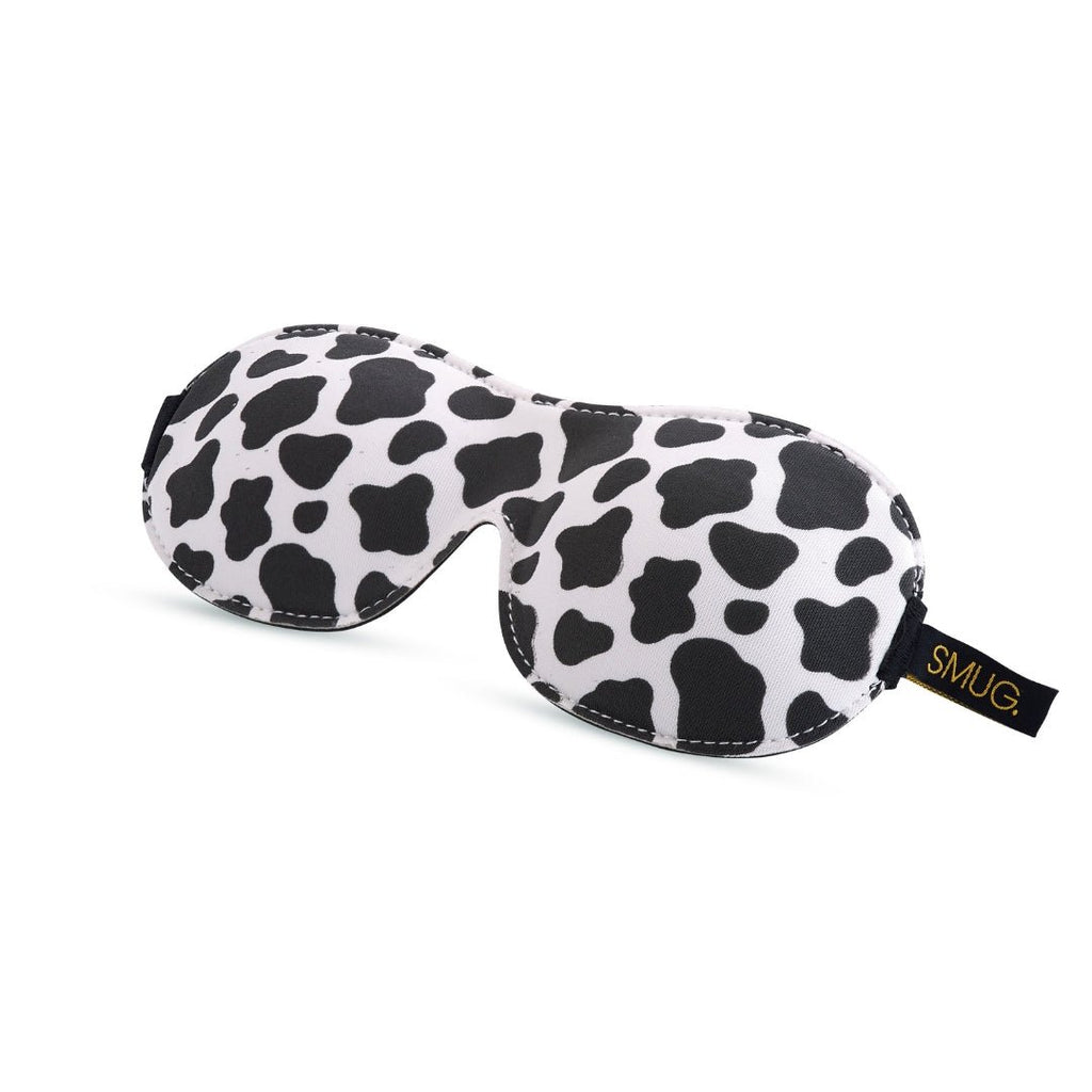 Contoured 3D black blackout sleep mask with cow print design by SMUG, featuring a comfortable fit for restful sleep.