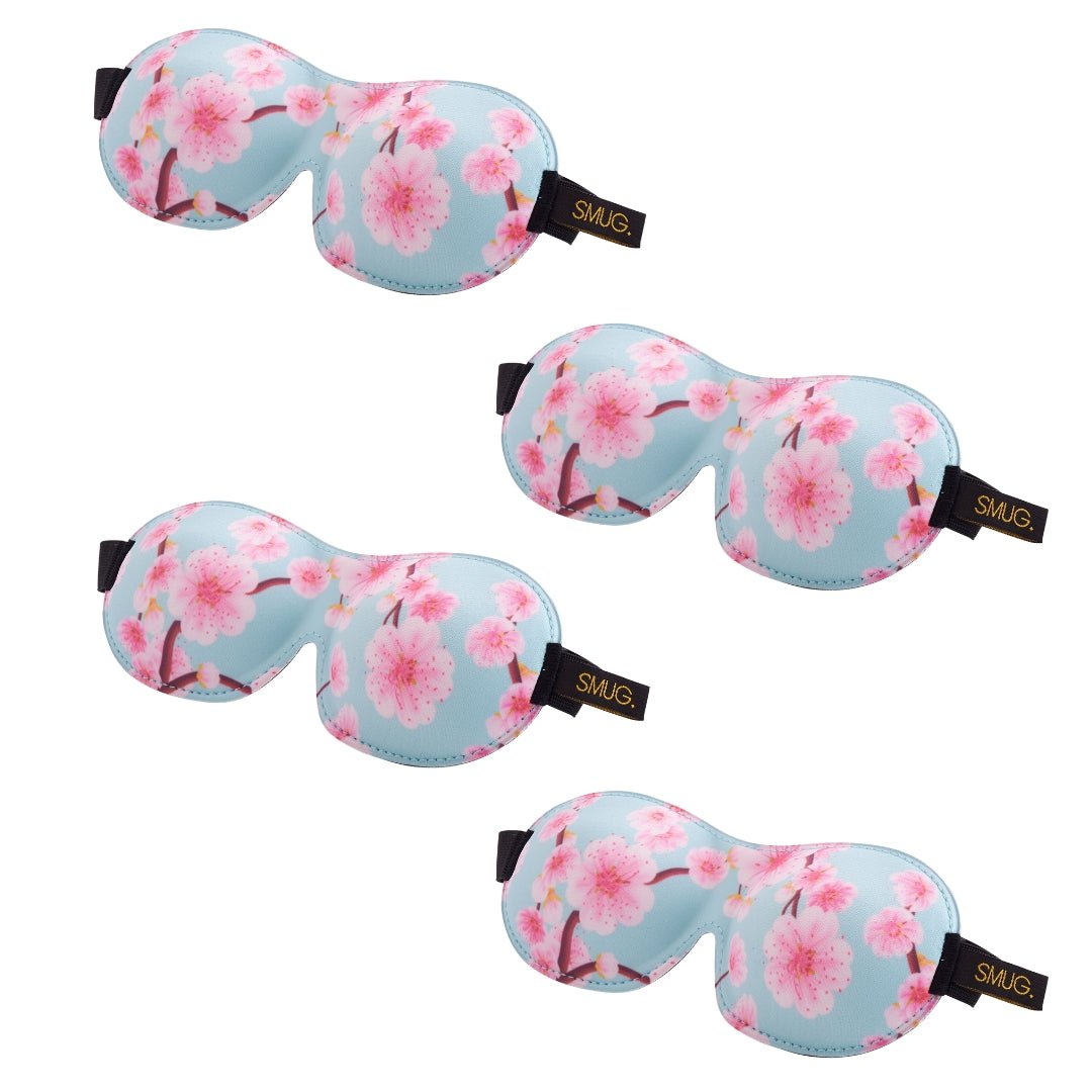 Contoured SMUG sleep mask set with cherry blossom design, soft fabric, and multiple eye masks for comfortable sleep.