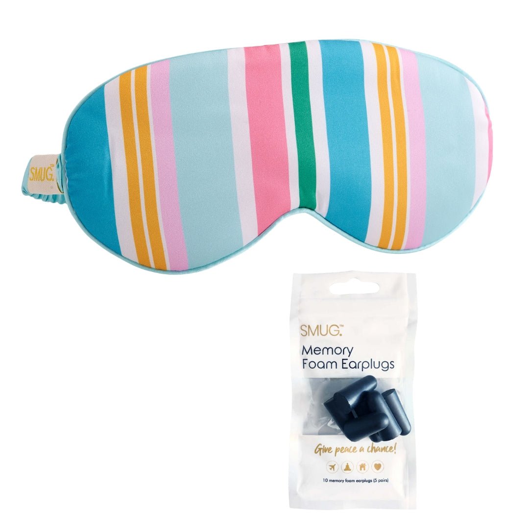 SMUG satin sleep mask with bold spring stripe print, featuring black accents and attached earplugs for comfortable rest.