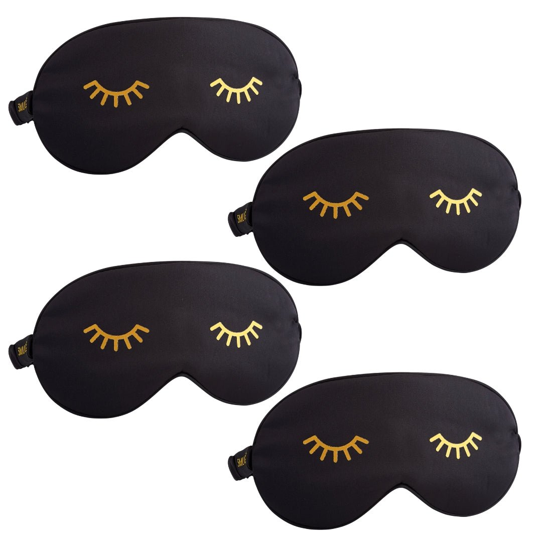 Set of SMUG satin sleep masks in various designs, including a black sleep mask with a wink detail, perfect for restful nights.