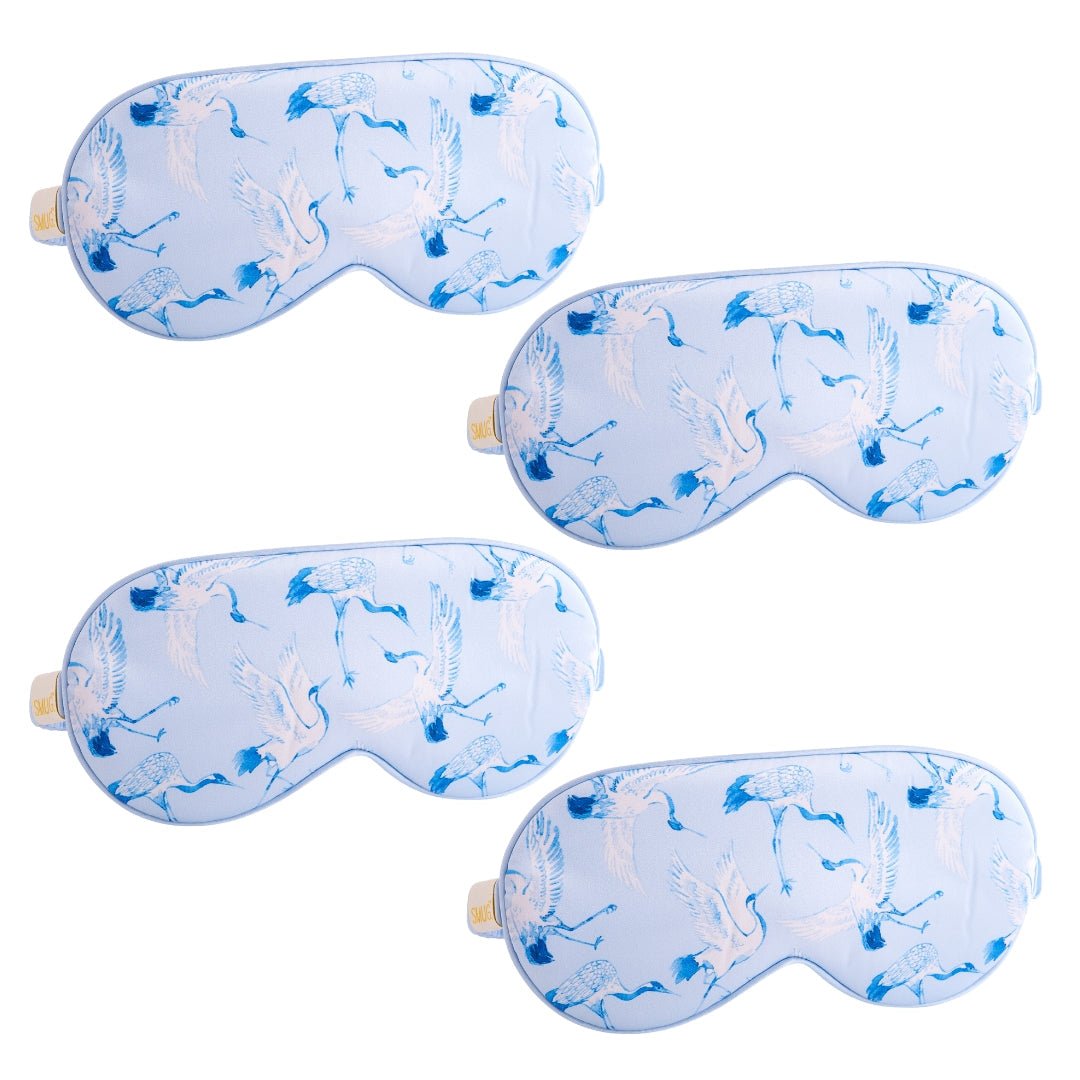 Set of SMUG satin sleep masks with various crane and floral designs, soft and comfortable for restful sleep.