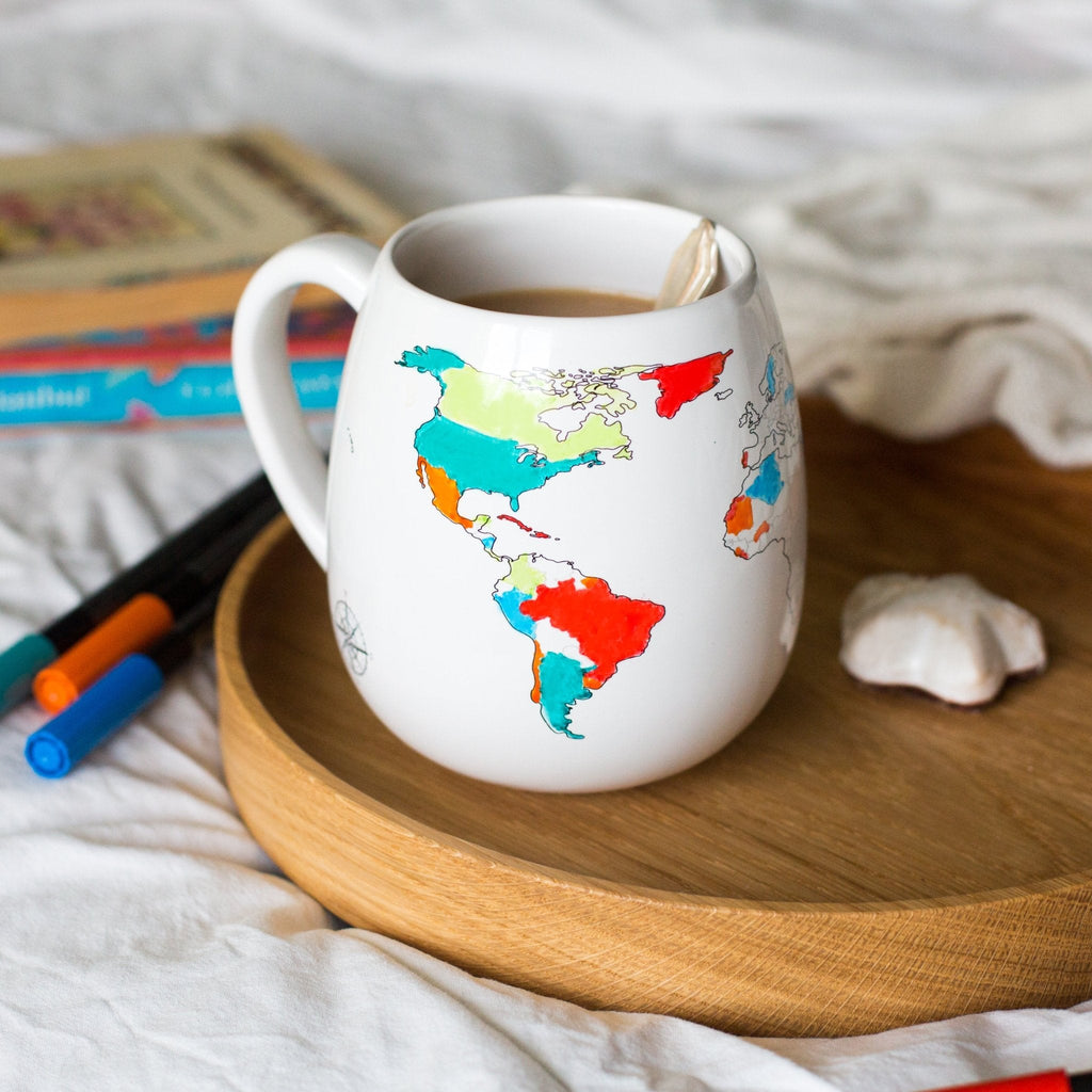 Trouvaille colour-in mug featuring a world map design, perfect as a travel gift for adventurers, shown with vibrant map details.