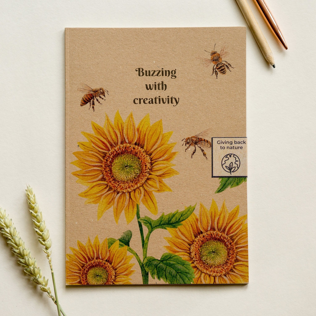 Trouvaille recycled paper notebook with illustrated sunflower and bee cover, perfect for creative writing and note-taking.