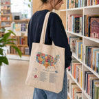 Cotton tote bag with US book lover design, featuring colorful book-themed artwork on a white background.