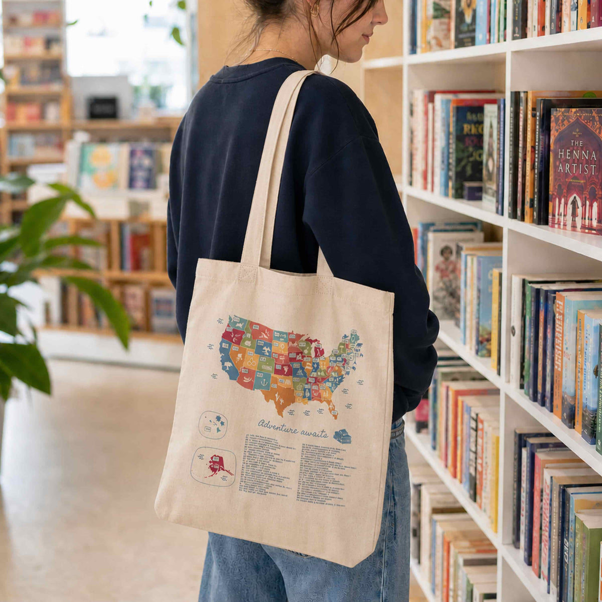 Cotton tote bag with US book lover design, featuring colorful book-themed artwork on a white background.