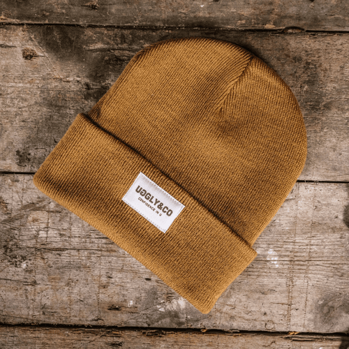 Mustard Uggly and Co beanie hat with a cozy knit texture, perfect for cold weather and casual style.