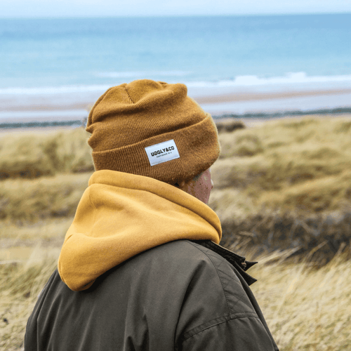 Mustard Uggly and Co beanie featuring a cozy knit design, perfect for cold weather and casual winter style.