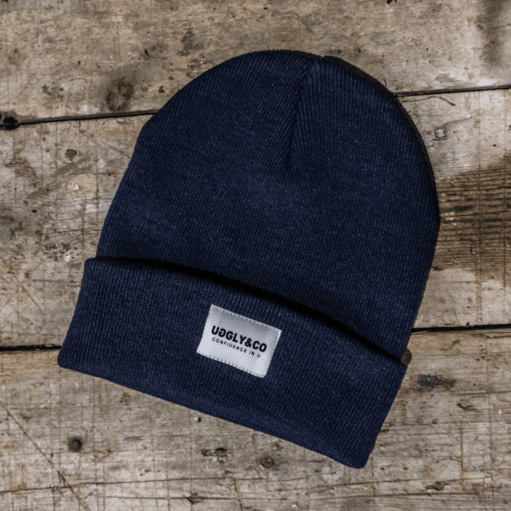 Navy Uggly and Co beanie made of soft knit fabric, featuring a snug fit and classic style perfect for casual wear.