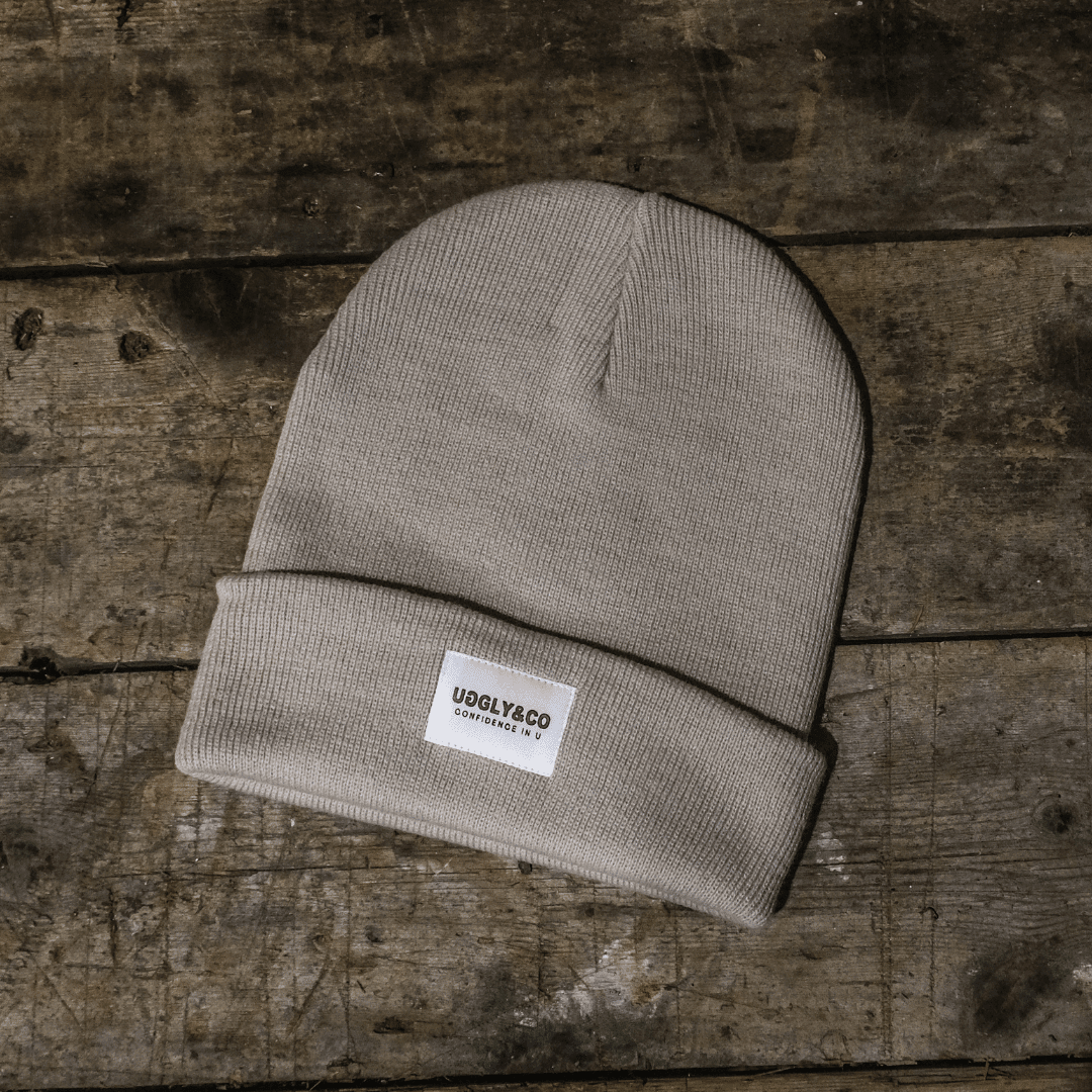 Grey oatmeal beanie by Uggly and Co, soft knit winter hat with a cozy, casual style shown on a model.