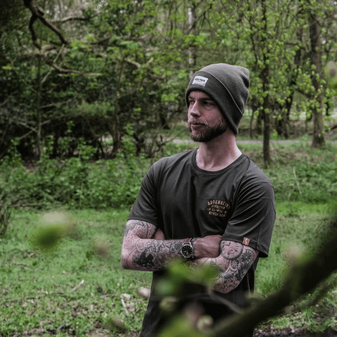 Olive Uggly and Co beanie hat made of soft knit fabric, featuring a snug fit and ribbed texture for cozy winter wear.