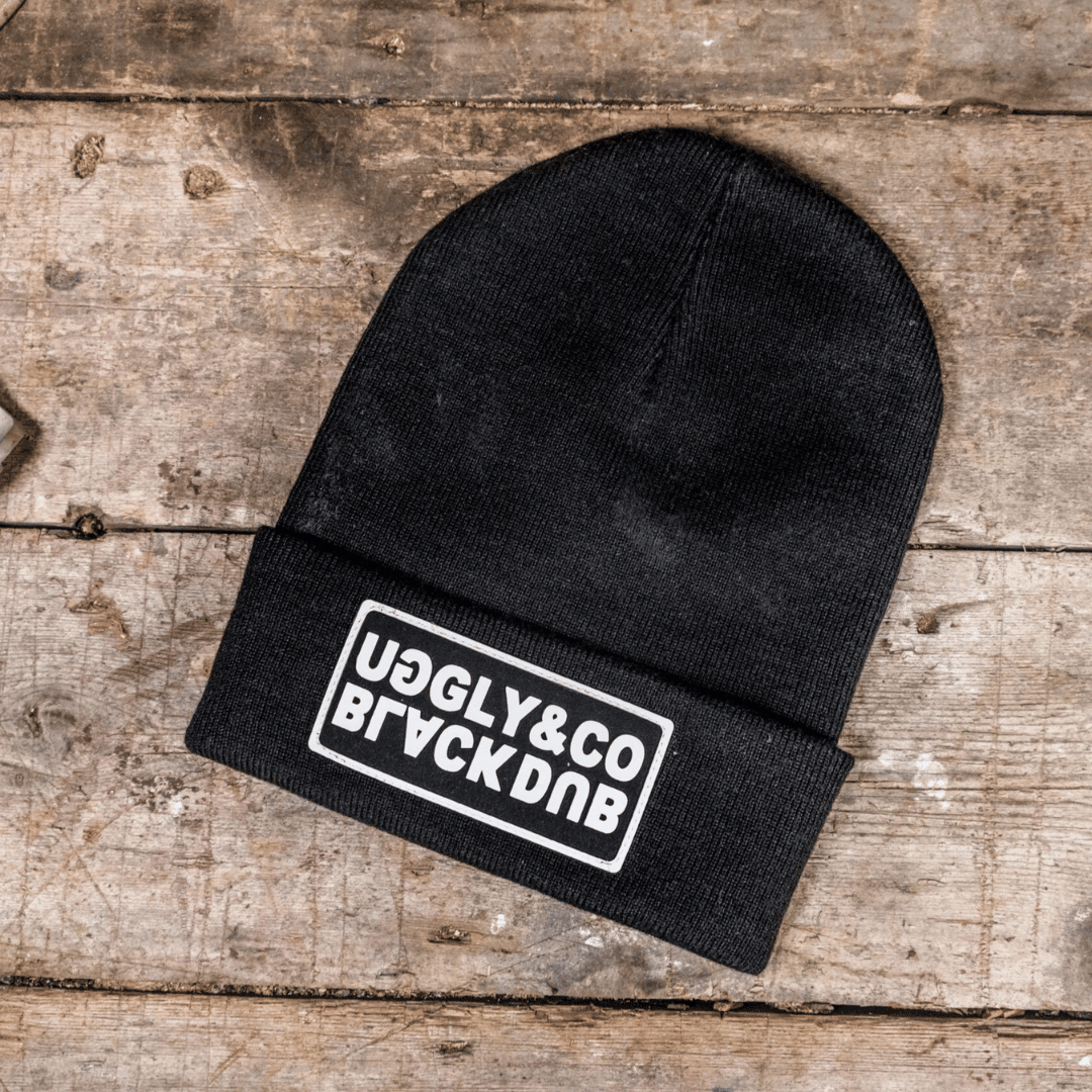 Black Uggly&Co Beanie featuring The Black Dub Garage logo, made of cozy knit fabric, designed for warmth and casual style.