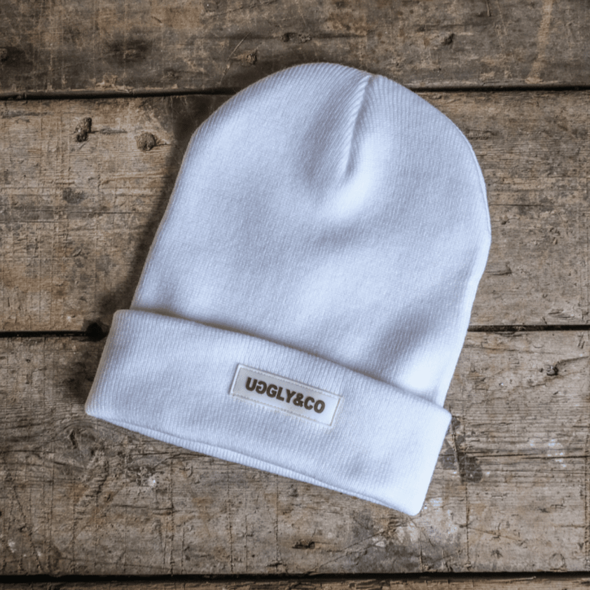 White Uggly and Co beanie, soft knit winter hat with a snug fit and folded brim, designed for warmth and style.