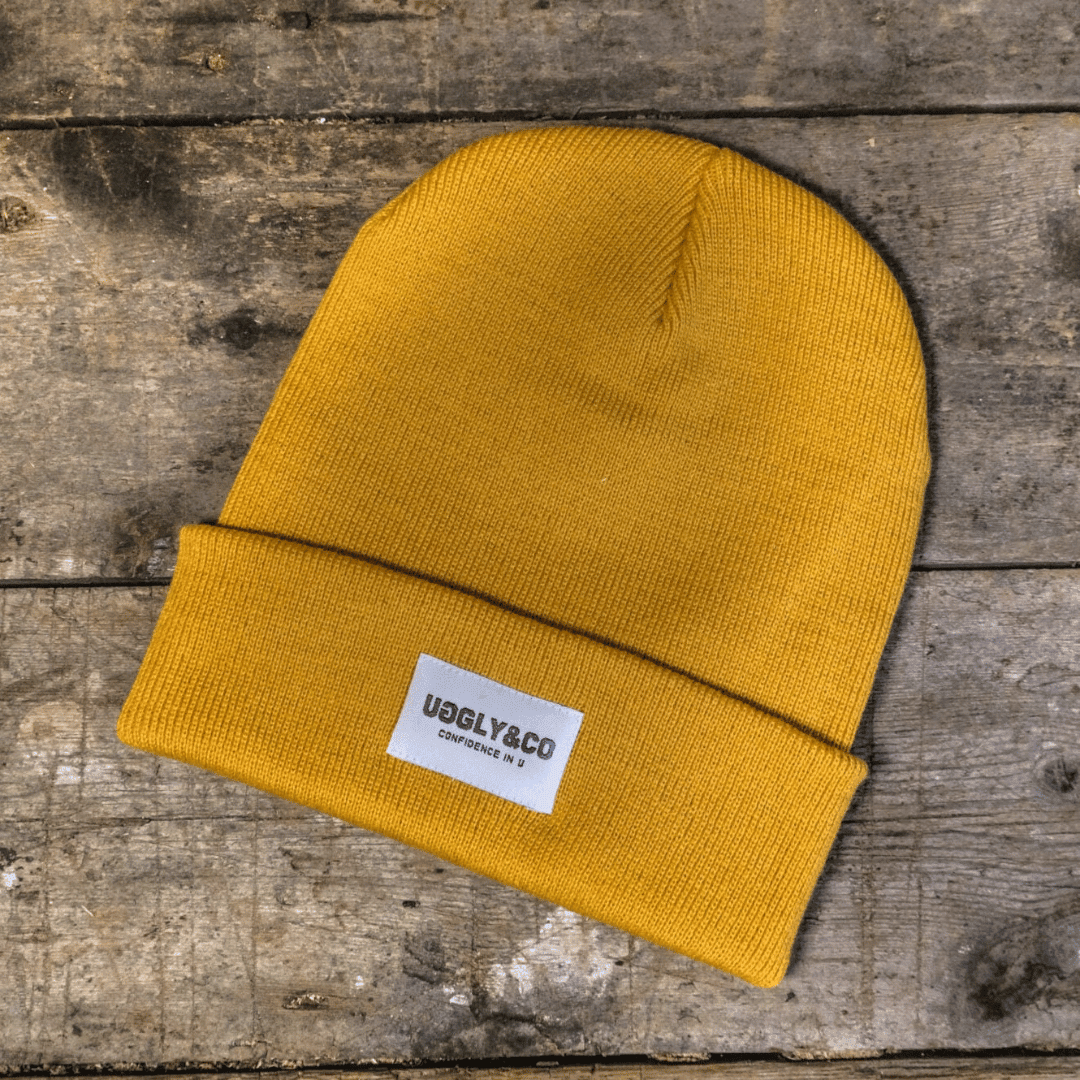 Yellow Uggly and Co beanie hat with a cozy, knitted texture, perfect for casual winter wear.