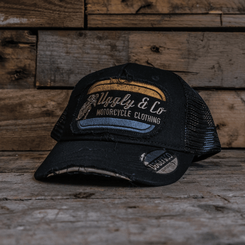 Black flat track trucker hat by Uggly and Co featuring a curved brim and mesh back for a casual, racing-inspired look.