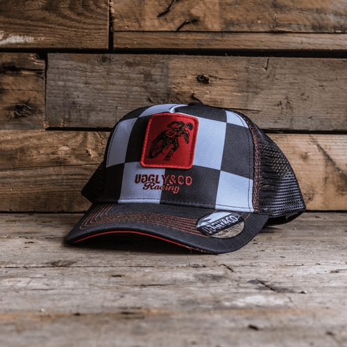 Uggly and Co chequered flat track trucker cap with adjustable mesh back and curved brim, stylish casual accessory.