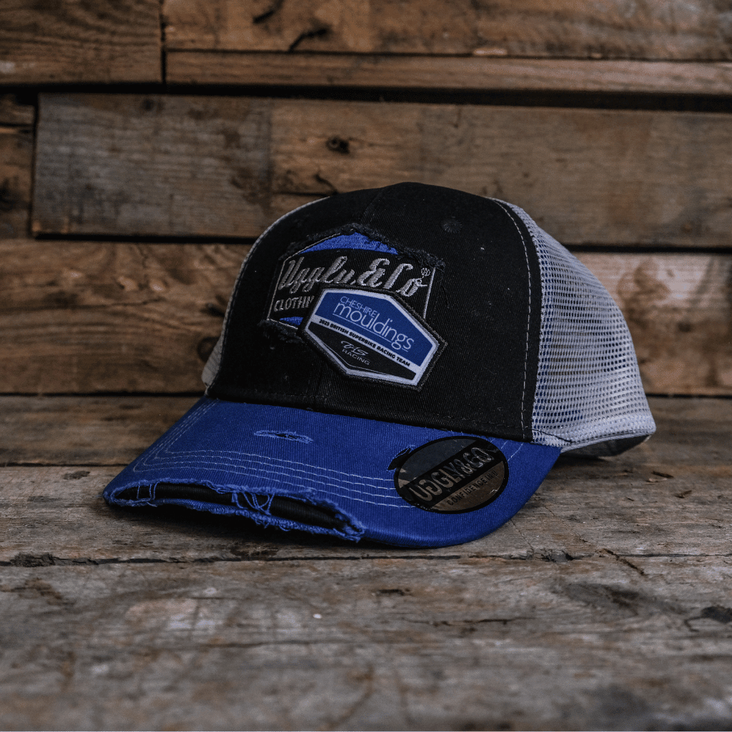 Uggly and Co diamond trucker cap featuring Cheshire Mouldings x TAS Racing branding, mesh back and structured front panel.