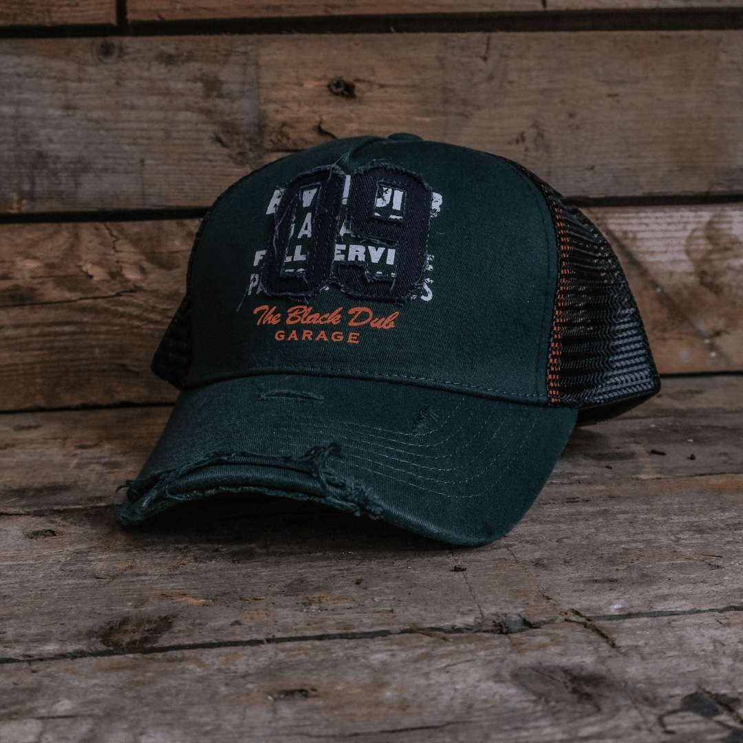 Green trucker cap with '09' logo, Uggly and Co branded biker-style baseball hat showing mesh back and adjustable strap.