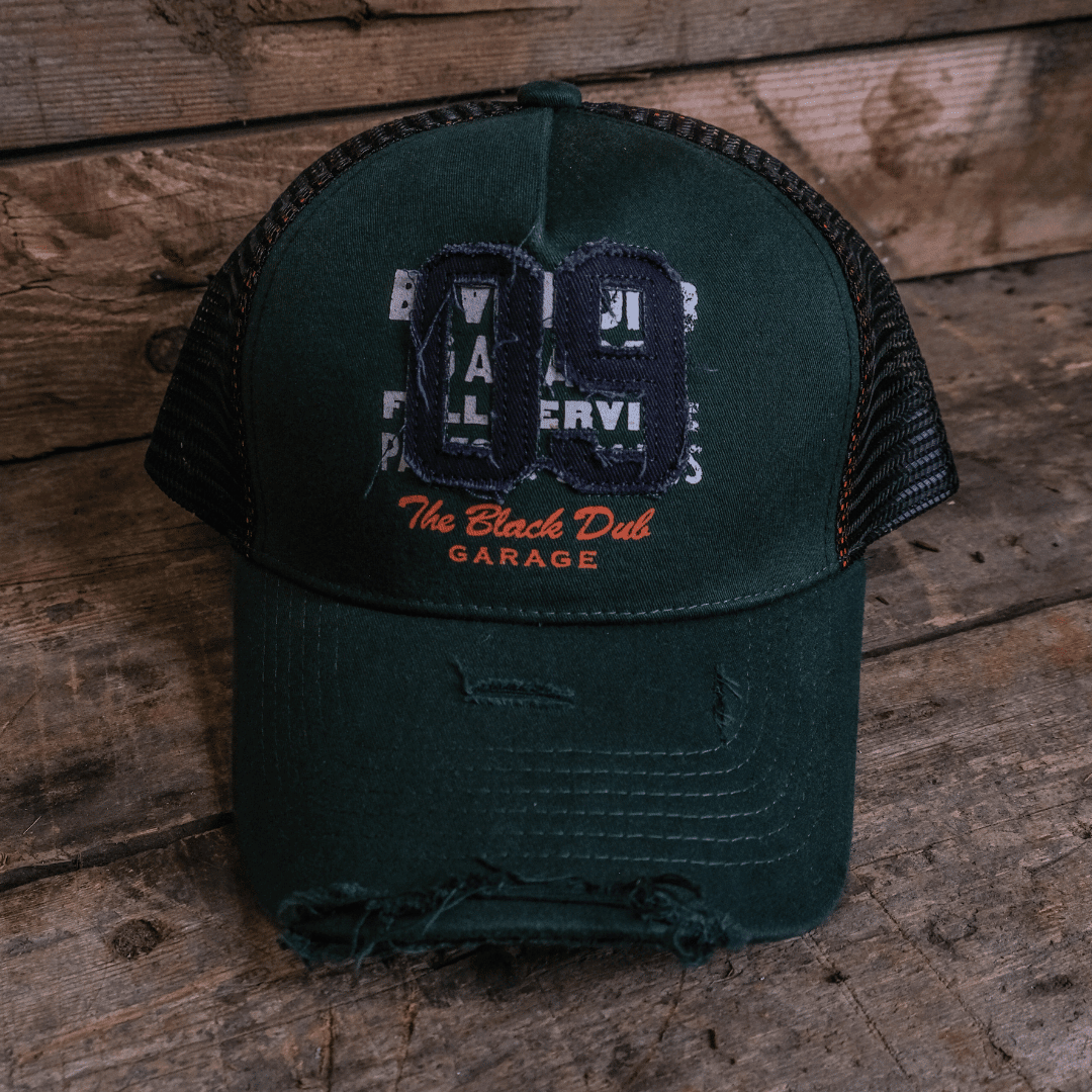 Green Uggly and Co trucker cap with "09" logo, adjustable mesh back, and classic curved brim for casual style.