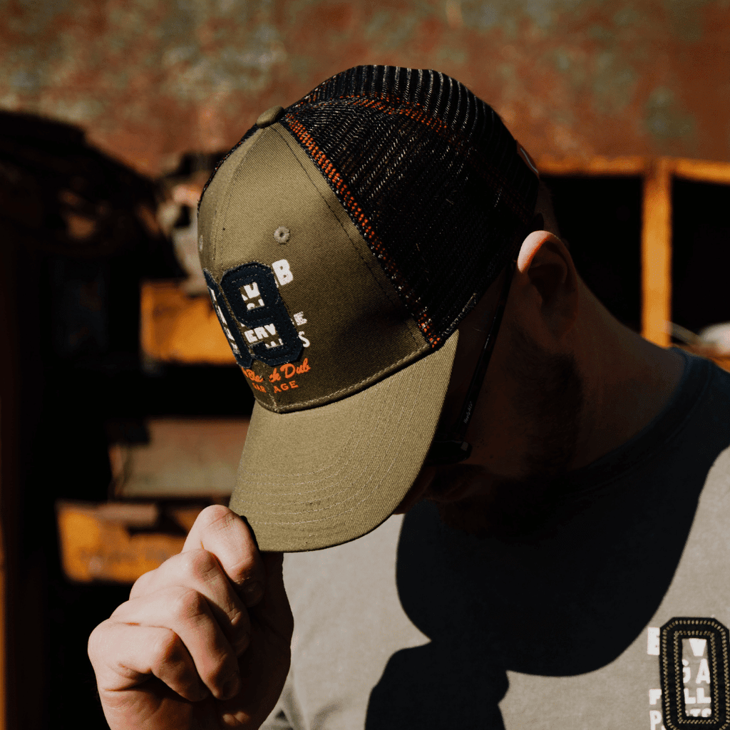 Green Uggly and Co trucker cap with "09" logo, featuring a mesh back and adjustable strap, casual headwear for everyday wear.