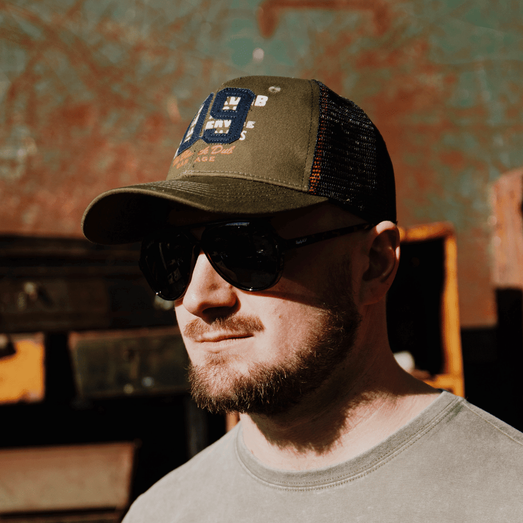 Green Uggly and Co trucker cap with "Parts & Spares 09" design, featuring a classic mesh back and adjustable snap closure.
