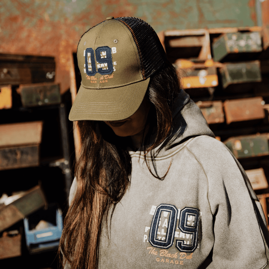 Green Uggly and Co trucker cap with "09" design, adjustable mesh back and curved brim, casual headwear for everyday style.