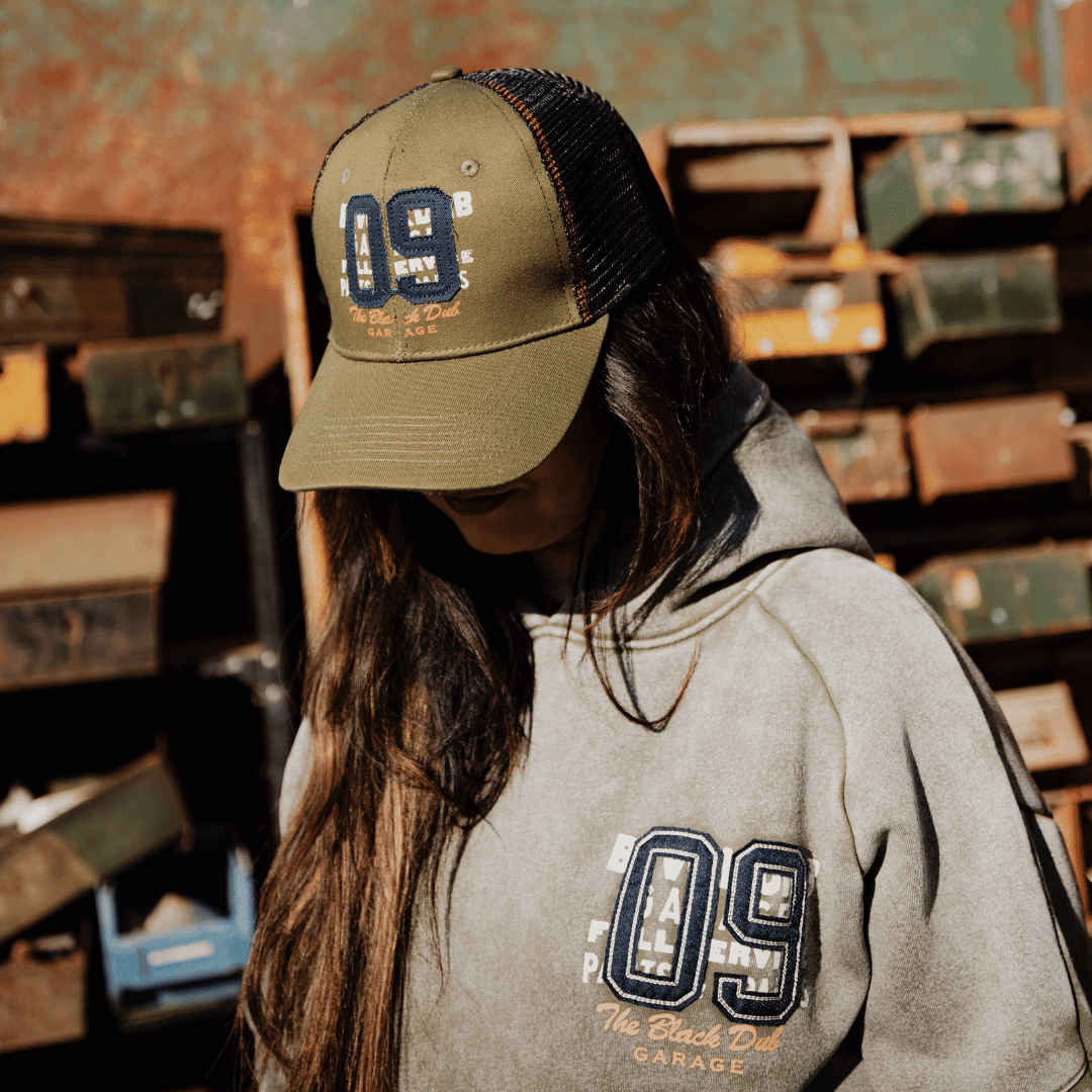 Green Uggly and Co trucker cap with "09" design, adjustable mesh back and curved brim, casual headwear for everyday style.
