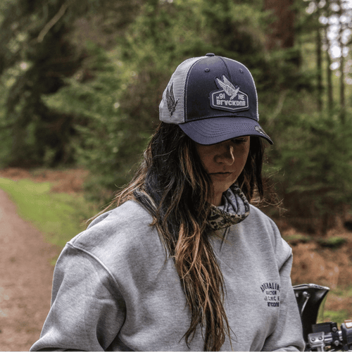 Uggly and Co Mile 9 Wings Trucker Cap with mesh back and embroidered wing design, classic trucker hat style.