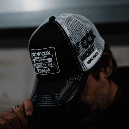 Uggly and Co official Carl Cox Motorsport trucker hat featuring a curved brim and adjustable snapback design.