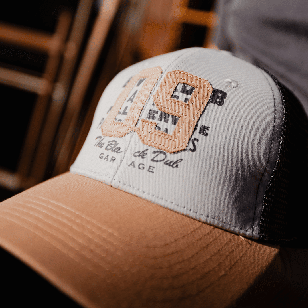 Uggly and Co Stone Parts & Spares '09' Trucker Cap with mesh back and adjustable snap closure, featuring a stylish stone-colored design.