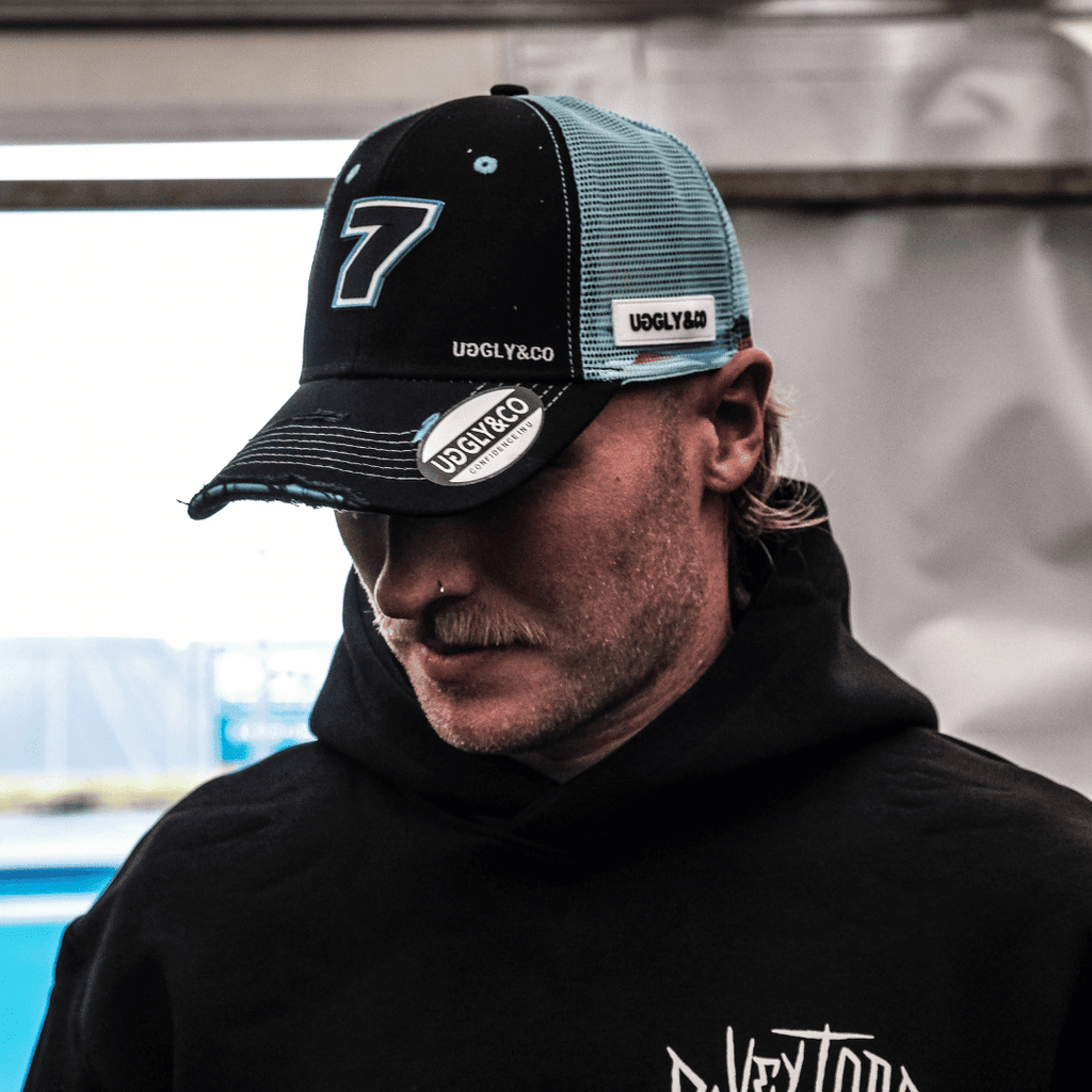 Black and blue Uggly and Co trucker cap featuring official Davey Todd merchandise logo and design.
