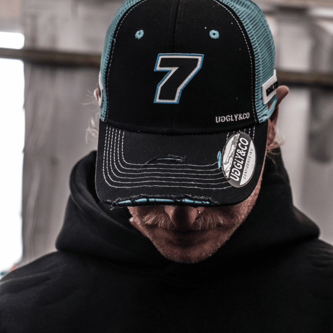 Black and blue Uggly and Co Trucker Cap featuring official Davey Todd merchandise, with a classic trucker hat design.