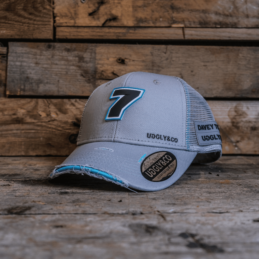 Steel grey Uggly and Co trucker hat featuring Davey Todd merchandise logo and mesh back, casual streetwear style.