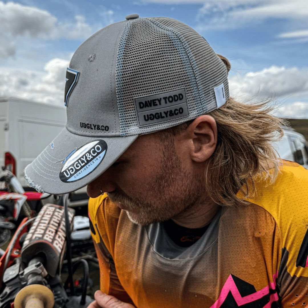 Uggly and Co steel grey official Davey Todd merchandise trucker cap with mesh back and curved brim.
