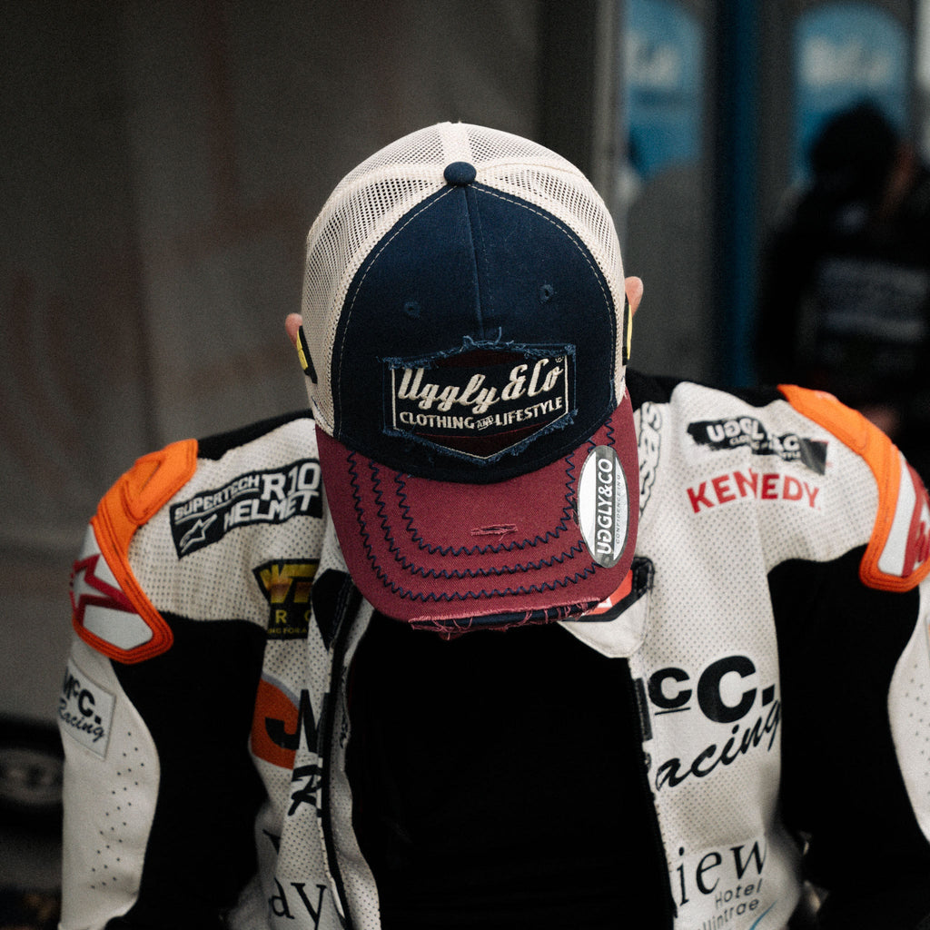Uggly and Co diamond trucker cap featuring Jeremy McWilliams #99 embroidered logo on structured mesh and curved brim.
