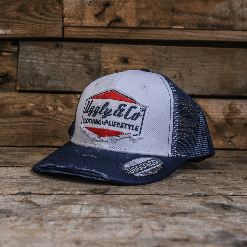 Navy blue and white diamond-patterned trucker cap by Uggly and Co, featuring mesh back and adjustable snap closure.