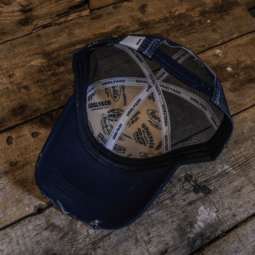 Navy blue and white diamond design Uggly and Co trucker cap with mesh back and adjustable strap.