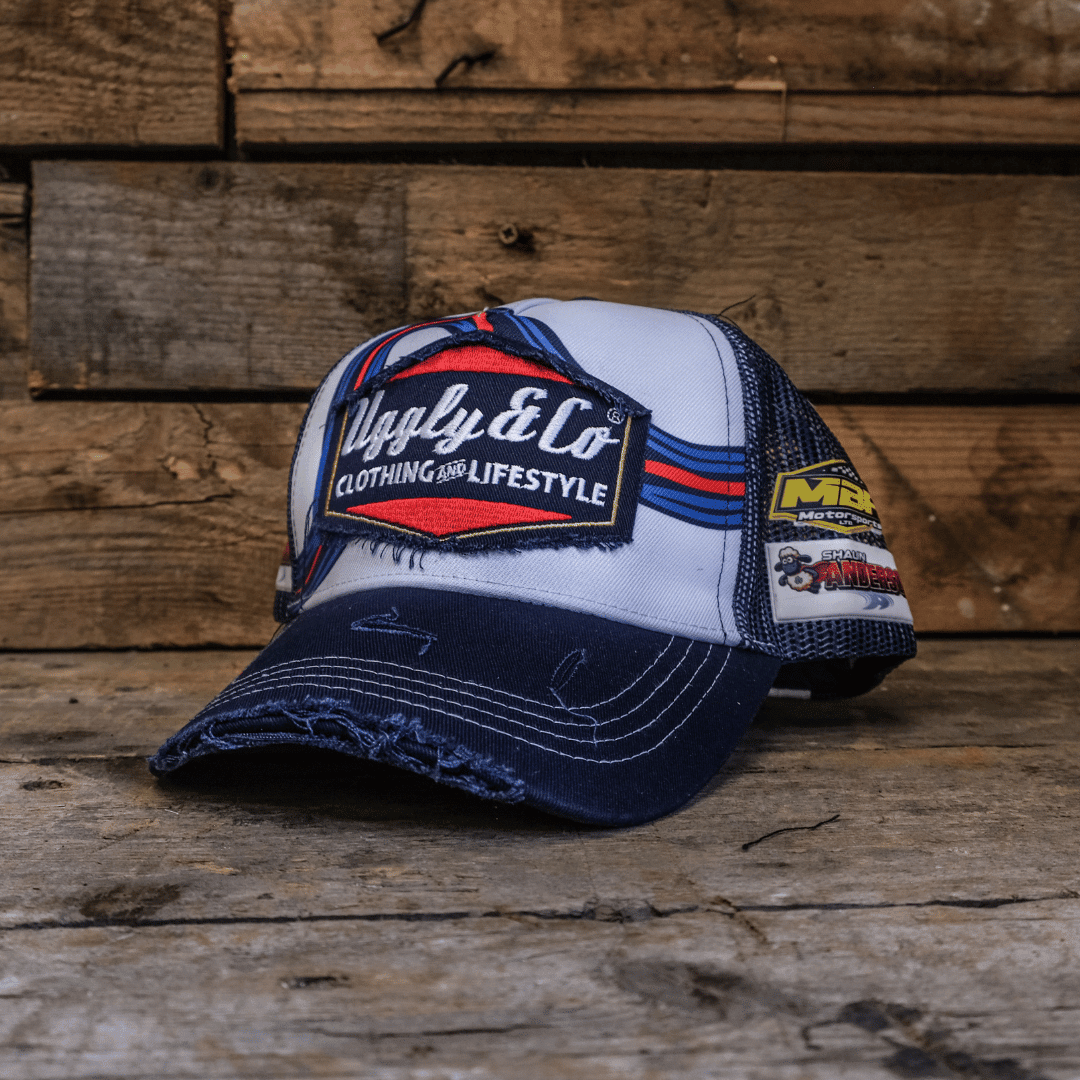 Retro blue and red diamond-patterned trucker cap by Uggly and Co, featuring classic mesh sides and adjustable strap.