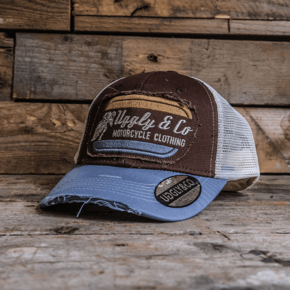 Dusty blue flat track trucker hat by Uggly and Co featuring a classic mesh back and adjustable snap closure.