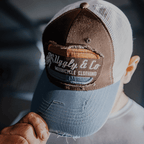 Dusty blue Uggly and Co flat track trucker cap with mesh back and curved brim, casual and sporty style.