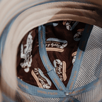 Dusty blue flat track trucker cap by Uggly and Co with mesh back and curved brim, stylish and casual outdoor hat.