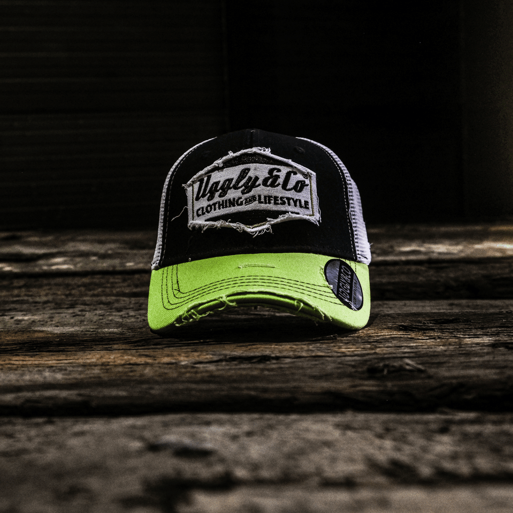 Yellow and white diamond-patterned Uggly and Co trucker cap with mesh back and curved brim.