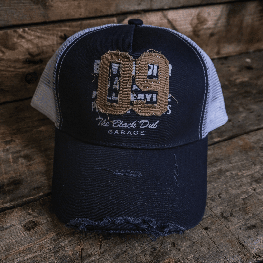 Vintage navy trucker cap with '09' logo from Uggly and Co featuring mesh back and structured front panel.
