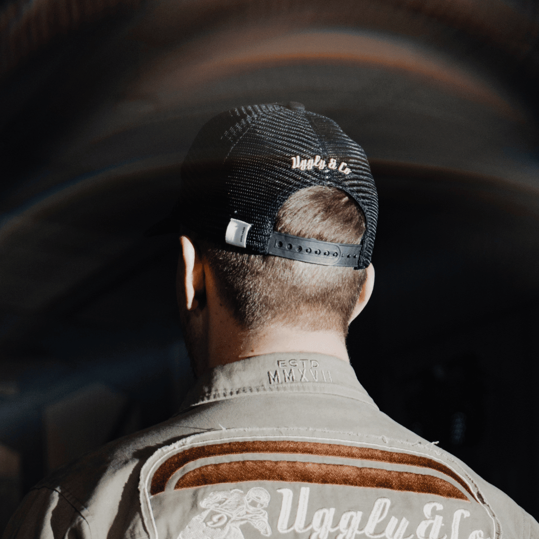 Vintage black flat track trucker hat by Uggly and Co, featuring a classic trucker cap style with mesh back for bikers and casual wear.
